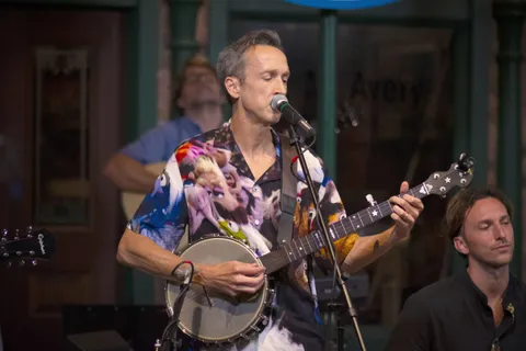 Josh Turknett playing banjo on stage